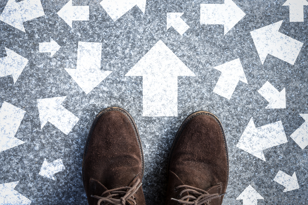 brown shoes standing on floor with assorted arrows printed in white